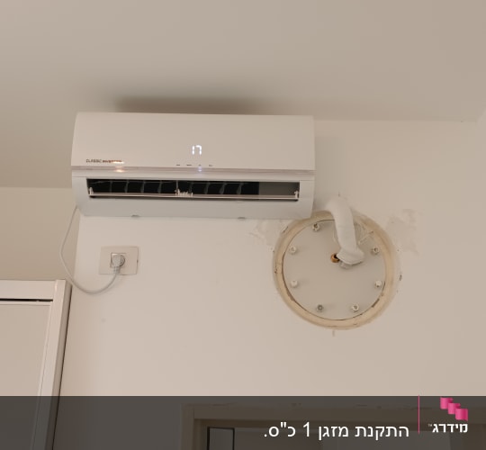 מזגן מותקן על קיר עם צינור חיבור